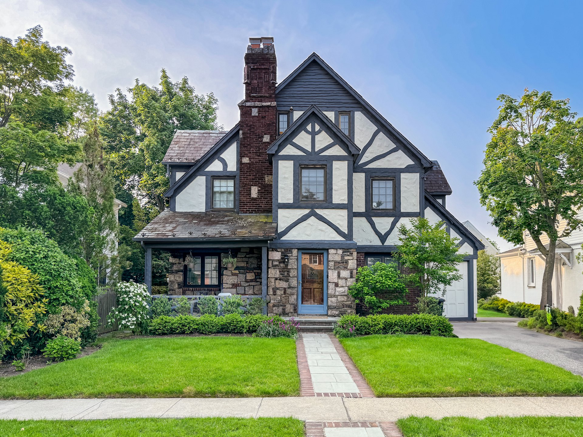 A Tudor-style home with a trimmed front lawn