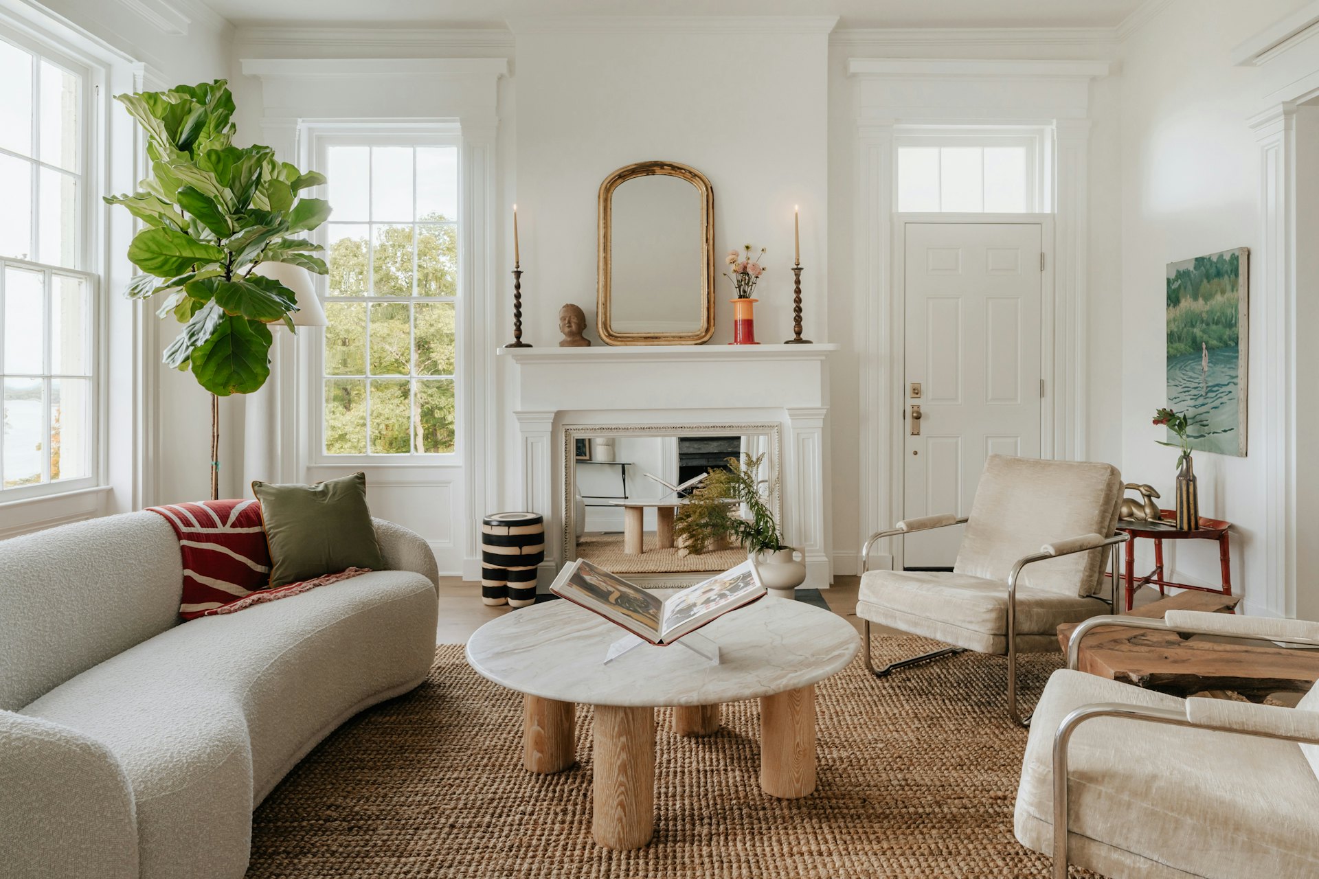 A bright living room with a fireplace and tall windows