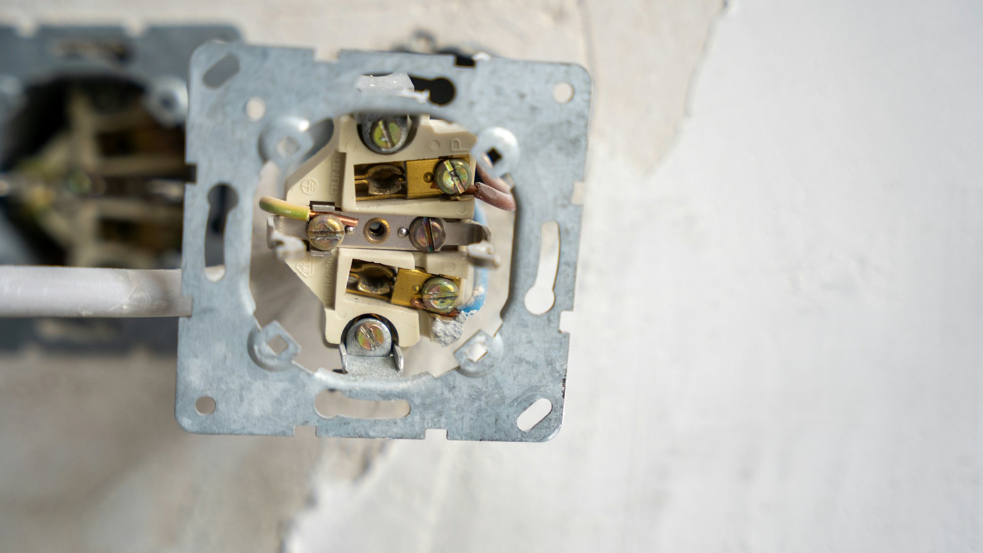 An electrical outlet box opened for wiring